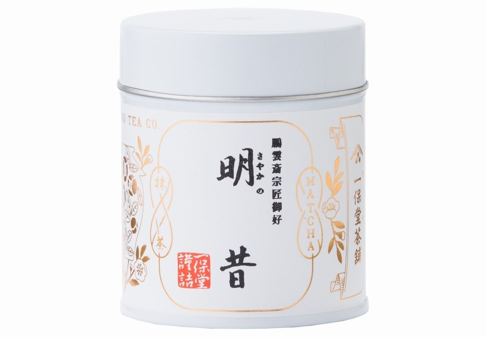 White tin of matcha tea with Japanese text and floral design.